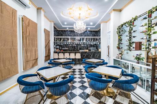 a restaurant with blue chairs and tables and a bar at Mekong Heritage Hotel in Nakhon Phanom