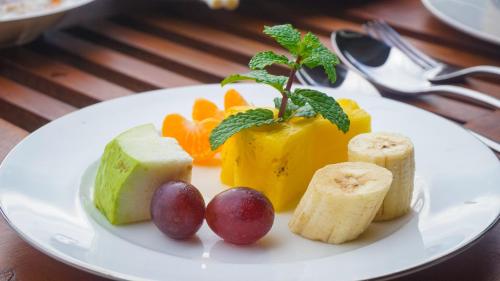 a plate of food with fruit on a table at Misty Hills Villa Kadugannawa in Kadugannawa