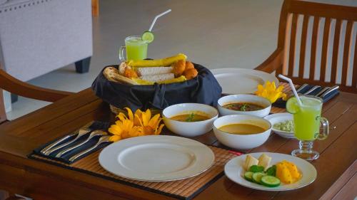 a table with plates of food and drinks on it at Misty Hills Villa Kadugannawa in Kadugannawa
