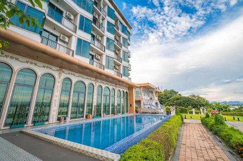 a hotel with a swimming pool in front of a building at Mekong Heritage Hotel in Nakhon Phanom