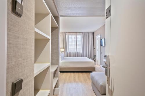 a hotel room with a bed and a book shelf at Acta CITY47 in Barcelona