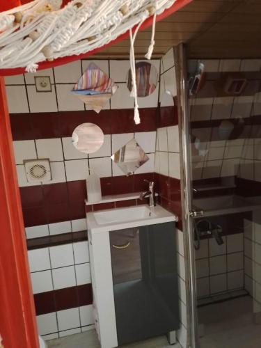 a small kitchen with a sink and red and white tiles at la woodstock in Xertigny
