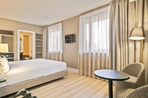 a bedroom with a bed and a table and chairs at Acta CITY47 in Barcelona