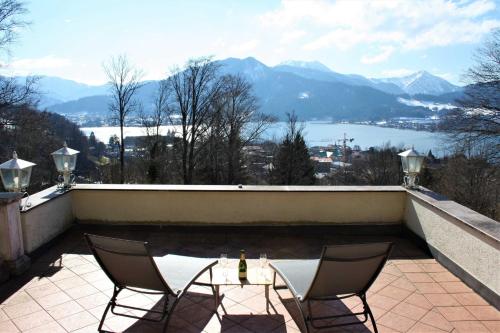 two chairs sitting on a patio with a view of the mountains at Ferienwohnung SeeFugium in Tegernsee