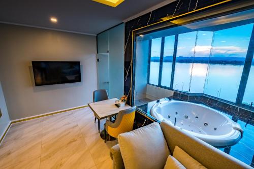 a large bathroom with a tub and a table at Mekong Heritage Hotel in Nakhon Phanom