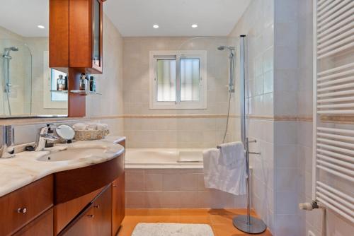 y baño con ducha, lavabo y bañera. en Casa Mosa, en Marbella