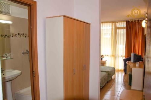 a bathroom with a cabinet and a bedroom with a bed at Hotel Mures in Saturn