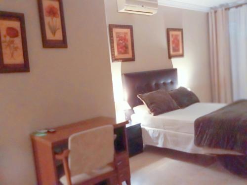 a bedroom with a bed and a desk and a bed and a bed at Hotel Sol Sanlúcar in Sanlúcar la Mayor