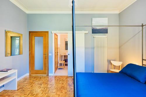 1 dormitorio con cama azul y escritorio en Villa Caramino, en Fara Novarese