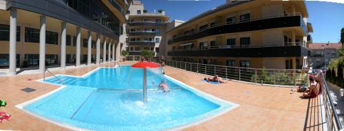 a swimming pool in a building with people in it at FLATSELECT Pinamar in Sanxenxo