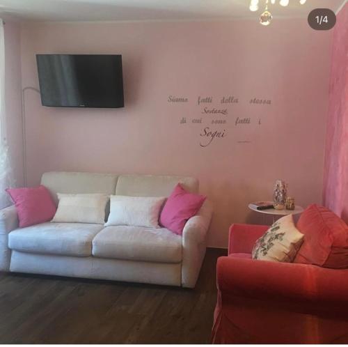 salon z kanapą i telewizorem na ścianie w obiekcie B&B BuongiornoNotte w mieście Bobbio