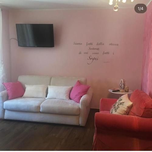 a living room with a couch and a tv on a wall at B&B BuongiornoNotte in Bobbio