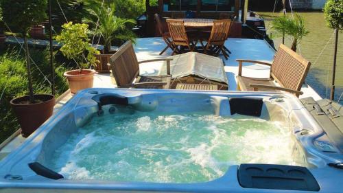 a jacuzzi tub with chairs in a backyard at Péniche Mirage in Carcassonne
