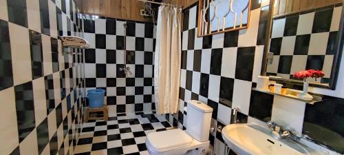 a bathroom with a black and white checkered wall at Central Gleneagles Heritage Resort Former Bungalow of Ex-TATA Chairman Russi Mody The Mall Road Darjeeling in Darjeeling