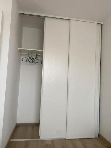 a white closet with two doors and a shelf at Appart COSY F2 Disneyland/Val d'Europe in Montévrain