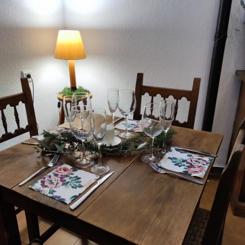 a wooden table with wine glasses and a lamp on it at Pensión Mesón La Lonja - Herbers in Herbés