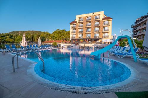 a swimming pool with a slide in a hotel at Veramar Hotel - All Inclusive & Free Beach in Kranevo
