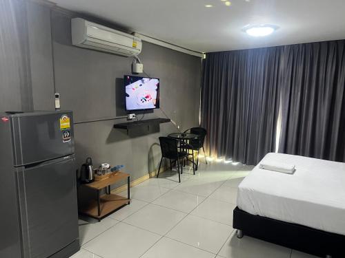a hotel room with a bed and a television in it at Apsara Inn in Pattaya South