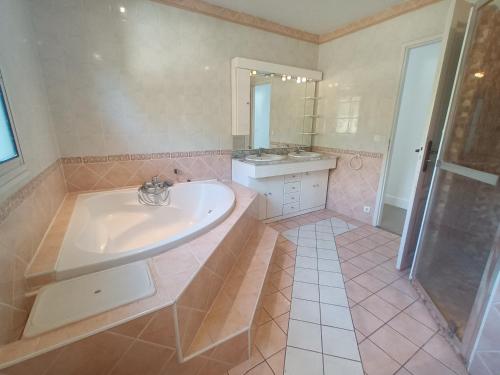 une salle de bain avec une baignoire, un lavabo et une douche dans l'établissement Bassin d'Arcachon belle villa moderne 4 chambres et piscine privée, à La Teste-de-Buch