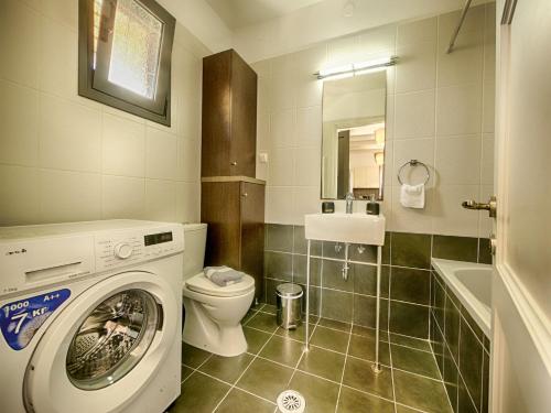 a bathroom with a washing machine and a toilet at Cozy Family Friendly Apartment with large garden close to beaches - Dirella in Kynopiástai