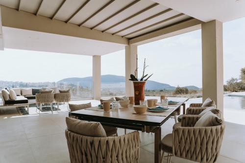 a dining room with a table and chairs at Villas Elini in Perdika
