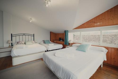 1 dormitorio con 2 camas y ventana en Santaia en Casal de Calma en O Pedrouzo