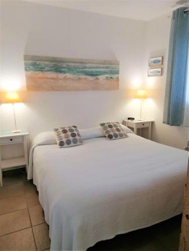 - une chambre dotée d'un grand lit blanc avec deux tables et deux lampes dans l'établissement Appartement Mas de la Mer, 5mn plage, piscine, à Saint-Aygulf