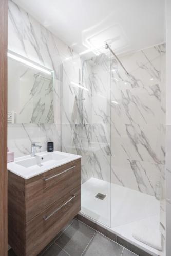 une salle de bain blanche avec une douche et un lavabo dans l'établissement La Maison Du Parc 4 Standing Terrasse Parking Wifi Clim, à Marseille