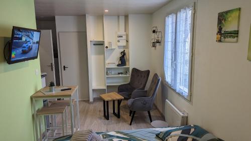 a small room with a bed and a table and a chair at studio zen tout neuf proche pithiviers 