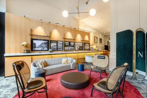 a lobby with a couch and chairs and a table at Hotel Nemzeti Budapest - MGallery in Budapest