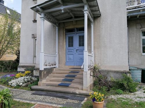 une maison avec une porte bleue et des escaliers dans l'établissement Am Elbradweg - Nichtraucher-Gästezimmer Weiland, à Dresde