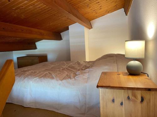 een slaapkamer met een bed en een tafel met een lamp bij Appartement La Rochelle, 1 pièce, 4 personnes - FR-1-246-582 in La Rochelle