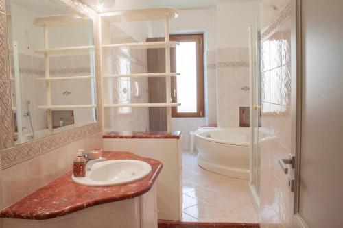 een badkamer met een wastafel en een bad bij Blu Mare Apartment in Alghero