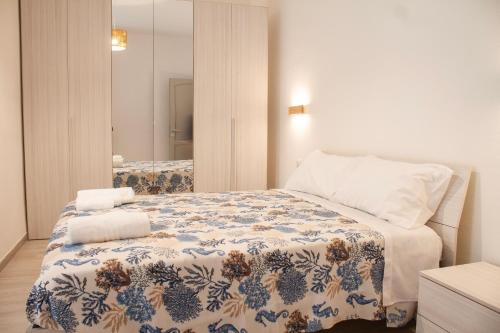 - une chambre dotée d'un lit avec une couverture bleue et blanche dans l'établissement Blu Mare Apartment, à Alghero
