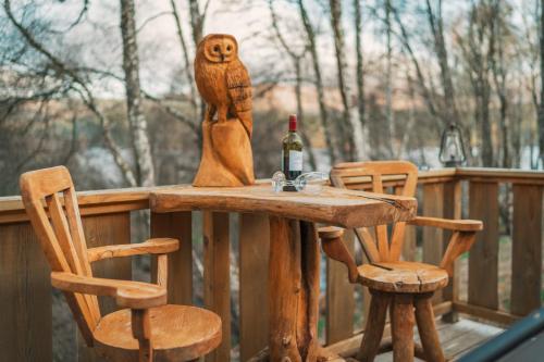 uma mesa de madeira com uma garrafa de vinho e 2 cadeiras em Caledonian Cabin em Invergarry