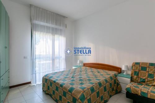 a bedroom with a bed and a couch and a window at Costa Del Sol in Lido di Jesolo