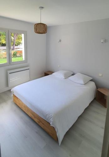 une chambre blanche avec un grand lit et une fenêtre dans l'établissement Bassin d'Arcachon belle villa moderne 4 chambres et piscine privée, à La Teste-de-Buch