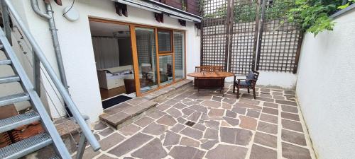 um pátio com uma mesa de madeira, uma mesa e cadeiras em Villa Clee Ferienwohnungen em Cleebronn