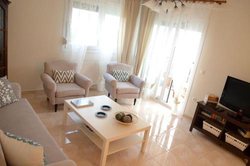 - un salon avec un canapé, des chaises et une table basse dans l'établissement Lemon Beach Front Apartment, Nikiti, à Nikiti