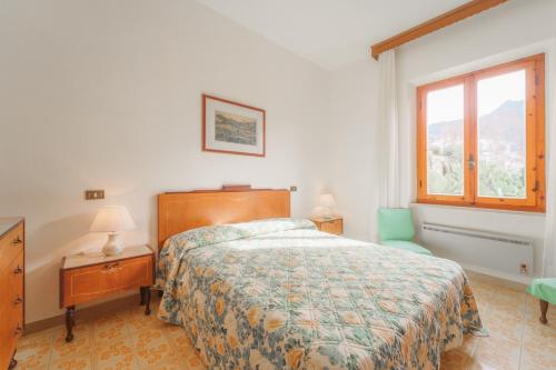 a bedroom with a bed and a chair and a window at Casa Fiorella a Pomonte-Goelba in Pomonte