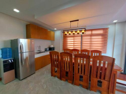 a kitchen with a table and chairs and a refrigerator at Cailey's Corner Family Resort in Tagaytay
