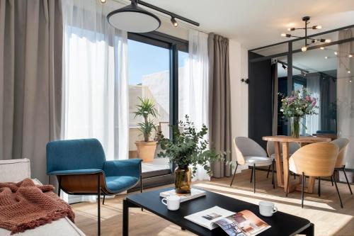 - un salon avec des chaises et une table dans l'établissement Magno Apartments Castilla, à Séville
