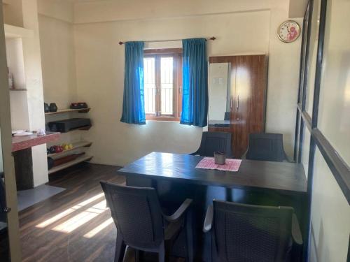 Habitación con mesa, sillas y ventana en NeelRatna Bed And Breakfast, en Shirdi