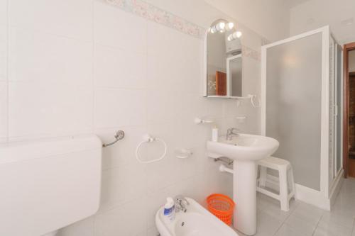 a white bathroom with a sink and a toilet at Casa Fiorella a Pomonte-Goelba in Pomonte