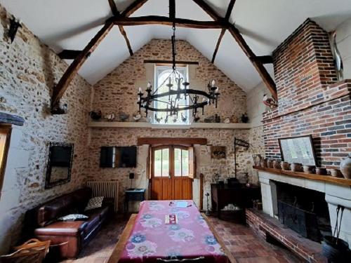 - un salon avec une table et une cheminée dans l'établissement La Chauvellière, un écrin de verdure dans un cadre historique, à Beaumont-la-Ronce