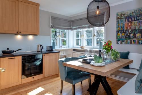 une cuisine avec une table en bois et des chaises bleues dans l'établissement Haus Boy, à Kampen