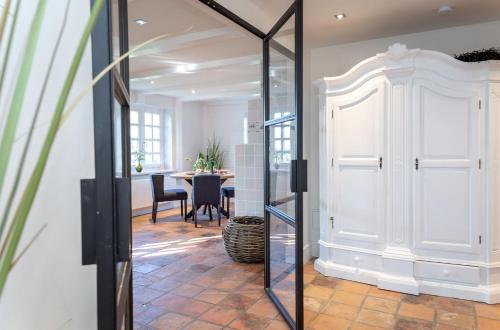 uma porta de vidro que dá acesso a uma sala de jantar com uma mesa em Haus Gordon em Wenningstedt