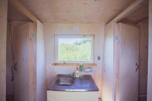 una pequeña cocina con fregadero y ventana en Lake Peipsi boathouses, en Varnja
