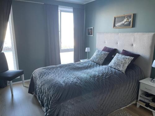 a bedroom with a bed with blue walls and a window at Ocean view apartment in Tromsø