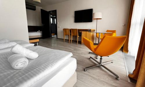 sypialnia z łóżkiem, stołem i krzesłem w obiekcie Hotel Žabčice w mieście Žabčice